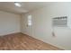 Bright bedroom features wood-look floors and a door to the backyard and window AC unit at 3327 W Mohawk Ln, Phoenix, AZ 85027