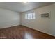 A simple bedroom with wood floors, one window and a wall air conditioning unit at 3327 W Mohawk Ln, Phoenix, AZ 85027