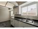 Bright kitchen with white cabinets, black countertops, and stainless steel sink at 3327 W Mohawk Ln, Phoenix, AZ 85027
