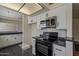Modern kitchen with black appliances, white cabinets, and stylish lighting at 3327 W Mohawk Ln, Phoenix, AZ 85027