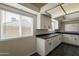 Well-lit kitchen featuring white cabinets, a dark countertop, and large windows at 3327 W Mohawk Ln, Phoenix, AZ 85027