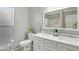 Bathroom showcasing white double vanity, toilet, and glass enclosed shower with custom tile surround at 3907 W Sharon Ave, Phoenix, AZ 85029