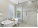 Bright bathroom featuring tub next to window, and walk-in shower with custom tile surround at 3907 W Sharon Ave, Phoenix, AZ 85029