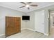 Bedroom showcasing a ceiling fan, dresser, mounted television, and white door leading to hall at 3907 W Sharon Ave, Phoenix, AZ 85029