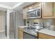 Kitchen features stainless steel appliances and sleek stone countertops at 3907 W Sharon Ave, Phoenix, AZ 85029