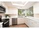 Well-lit kitchen featuring stainless steel appliances, bright cabinetry, and corner windows at 5465 N 78Th St, Scottsdale, AZ 85250