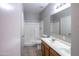 Bathroom with double sinks, tiled floors, and a shower and tub combination featuring a neutral color palette at 6538 W Elwood St, Phoenix, AZ 85043