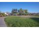 View of the community park with lush green grass, a covered picnic area, and a basketball court at 6538 W Elwood St, Phoenix, AZ 85043