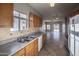 Well-lit kitchen features wood cabinets, a stainless-steel sink, and an open view of the living area at 6538 W Elwood St, Phoenix, AZ 85043