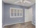Bedroom showcasing neutral blue walls, tile floor, white shutters, and a ceiling fan at 7164 W Paso Trl, Peoria, AZ 85383