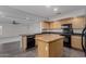 Open kitchen features black appliances, island and tile floor at 7164 W Paso Trl, Peoria, AZ 85383