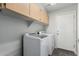 A well-equipped laundry room featuring a washer and dryer with storage cabinets above at 7164 W Paso Trl, Peoria, AZ 85383