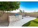 Outdoor kitchen and BBQ area with built-in grill and fire pit, perfect for entertaining at 7164 W Paso Trl, Peoria, AZ 85383