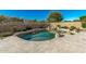 Backyard pool featuring stone accents and a small rock waterfall feature, surrounded by lush landscaping at 7164 W Paso Trl, Peoria, AZ 85383