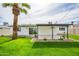 This backyard features a spacious lawn and a covered patio perfect for outdoor seating, complemented by a tall palm tree at 7346 E Mckinley St, Scottsdale, AZ 85257