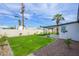 Large backyard with green grass, a white fence, a palm tree, and a covered patio perfect for entertaining at 7346 E Mckinley St, Scottsdale, AZ 85257