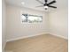 Bright bedroom with light wood-look floors, a ceiling fan, neutral walls and a window offering a view of the outside at 7346 E Mckinley St, Scottsdale, AZ 85257