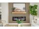 Modern electric fireplace with wood slat accent wall, mantle, and a green houseplant at 7346 E Mckinley St, Scottsdale, AZ 85257