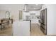 Well-lit kitchen with white cabinets, a stainless steel refrigerator, and an island at 7346 E Mckinley St, Scottsdale, AZ 85257
