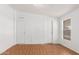 Neutral bedroom featuring laminate flooring and multiple closets and a window at 7707 E Garnet Ave, Mesa, AZ 85209