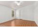 Spacious bedroom with light wood floors, white walls, and a window at 7707 E Garnet Ave, Mesa, AZ 85209