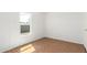 Small bedroom with a window, laminate flooring, white walls, and a door at 7707 E Garnet Ave, Mesa, AZ 85209