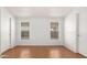 Bright bedroom with two windows, laminate flooring, and white walls and doors at 7707 E Garnet Ave, Mesa, AZ 85209