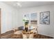 Dining area featuring hardwood floors, white walls, a modern table, and a ceiling fan at 7707 E Garnet Ave, Mesa, AZ 85209
