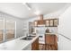 Well-lit kitchen with ample countertop space and white appliances; features a central island sink at 7707 E Garnet Ave, Mesa, AZ 85209