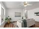 Bright living room with hardwood floors, white walls, modern decor, and a ceiling fan at 7707 E Garnet Ave, Mesa, AZ 85209