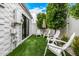 Inviting backyard featuring artificial turf, landscaping, and white Adirondack chairs at 7770 E Camelback Rd # 11, Scottsdale, AZ 85251