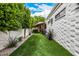 Backyard featuring artificial turf, landscaping, and a brick home exterior at 7770 E Camelback Rd # 11, Scottsdale, AZ 85251