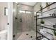 Modern bathroom with a glass-enclosed shower, complemented by stylish shelving and natural light from the window at 7770 E Camelback Rd # 11, Scottsdale, AZ 85251