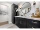 Elegant bathroom featuring a black vanity with gold accents, a round mirror, and ample storage space at 7770 E Camelback Rd # 11, Scottsdale, AZ 85251