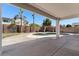 This backyard features a covered patio, a pool surrounded by concrete, a privacy fence, and two palm trees at 9618 E Monterey Ave, Mesa, AZ 85209
