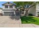 Charming two-story home features a two-car garage and well-maintained front yard with mature tree providing shade at 9618 E Monterey Ave, Mesa, AZ 85209