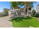 Inviting two-story home with a two-car garage, lush green lawn, and mature tree, offering a warm, welcoming feel at 9618 E Monterey Ave, Mesa, AZ 85209