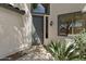 Close-up view of the front door of the home with a gray door and lush greenery creating a warm welcome at 9618 E Monterey Ave, Mesa, AZ 85209