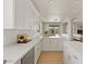Large kitchen with white cabinetry, an island, and open access to the living room and backyard at 9618 E Monterey Ave, Mesa, AZ 85209