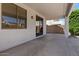This patio has a concrete floor, white stucco wall, and a window with brown blinds facing the backyard at 9618 E Monterey Ave, Mesa, AZ 85209