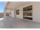 This patio features a concrete floor, white support beams, and a sliding glass door that reflects the backyard at 9618 E Monterey Ave, Mesa, AZ 85209