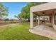 Lush backyard with a covered patio, built-in grill, and serene water fountain overlooking the greenbelt at 9665 E Nido Ave, Mesa, AZ 85209