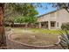 Lush backyard featuring a fountain, mature trees, and a covered patio at 9665 E Nido Ave, Mesa, AZ 85209