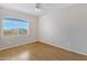 Well-lit bedroom with wood-look floors and a large window to let in natural light at 9665 E Nido Ave, Mesa, AZ 85209