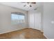 Bright bedroom featuring a ceiling fan, wood-look floors and a closet with sliding doors at 9665 E Nido Ave, Mesa, AZ 85209