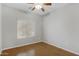Bright bedroom featuring a ceiling fan, wood-look floors and a large window at 9665 E Nido Ave, Mesa, AZ 85209