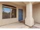 Inviting entryway featuring a blue front door, window, and textured exterior walls at 9665 E Nido Ave, Mesa, AZ 85209