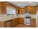 Charming kitchen featuring wood cabinets, granite counters, and stainless steel appliances at 9665 E Nido Ave, Mesa, AZ 85209
