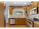 Well-lit kitchen features wood cabinets, granite countertops, stainless steel appliances, and window view at 9665 E Nido Ave, Mesa, AZ 85209