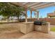 Outdoor kitchen area on covered patio with stone flooring and built-in BBQ grill at 9665 E Nido Ave, Mesa, AZ 85209